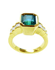 An emerald and princess cut diamonds ring for women, lateral profile visible.