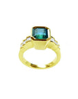 18K gold ring with a 2.10 ct emerald-cut bluish-green emerald and bezel-set princess-cut diamonds.