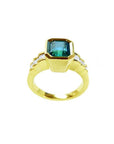 18K gold ring with a 2.10 ct emerald-cut bluish-green emerald and bezel-set princess-cut diamonds.