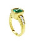 This 18k gold emerald bezel set ring for women displays the top and side profile.