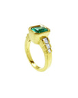 18K gold ring with a 2.10 ct emerald-cut emerald bezel set, flanked by three princess-cut diamonds.