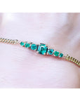 Women's 14K yellow gold bracelet with sparkling medium deep green Colombian emeralds.