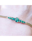 Women's 14K yellow gold bracelet with sparkling medium deep green Colombian emeralds.