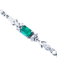 14K white gold bracelet with a rectangular deep bluish-green emerald and three diamond accents on each side.