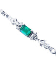 14K white gold bracelet with a rectangular deep bluish-green emerald and three diamond accents on each side.