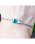 A square emerald-cut bracelet Colombian emerald with accent diamond in 14k white gold.