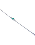 14K white gold bracelet with a central emerald-cut Colombian emerald and diamond accents.