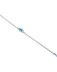 14K white gold bracelet with a central emerald-cut Colombian emerald and diamond accents.