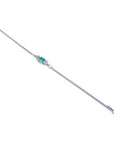 14K white gold bracelet with a central emerald-cut Colombian emerald and diamond accents.