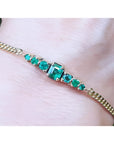 Lady’s bracelet featuring natural Colombian emeralds set in 14K yellow gold, showcasing sparkling medium deep green stones from the renowned Muzo mine.