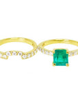 An emerald ring with the matching band set aside.