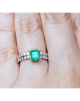 A natural emerald bridal ring with matching band set on a person's finger.