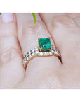 1.39 carat emerald bridal ring set with matching diamond band in 14K gold on a hand.