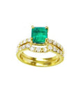 An emerald bridal ring with set matching band with diamonds en 14k yellow gold.