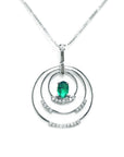 A distant view of a triple circle of life natural colombian emerald pendant made in 14k white gold.