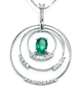 A frontside view of a triple circle of life pendant adorned with natural diamonds, in the center an oval cut colombian emerald.