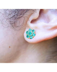 18K yellow gold stud earring with six round-cut natural Colombian emerald petals, worn on an ear.