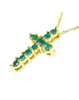 14K yellow gold cross pendant necklace with eleven round-cut Colombian emeralds.