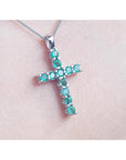 18K white gold cross pendant necklace with eleven round-cut natural Colombian emeralds.