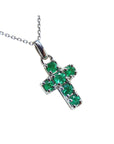Cross-shaped natural colombian emerald pendant on chain made of 14k white gold.