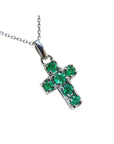 Cross-shaped natural colombian emerald pendant on chain made of 14k white gold.