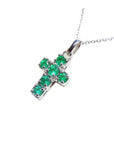 A genuine Muzo mine colombian round cut emerald cross pendant dangling from a 14k white gold necklace.