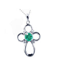 Colombian emerald cross pendant necklace round cut prong set in a 14k white gold mounting.