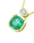 This 18k yellow gold cushion cut emerald pendant necklace displays the topside and galley perspective.