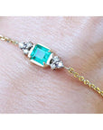 Bracelet for women 0.85 carat natural Colombian emerald with side diamonds accent yellow gold 14k on a wrist.