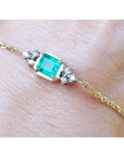 Bracelet for women 0.85 carat natural Colombian emerald with side diamonds accent yellow gold 14k on a wrist.