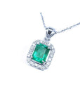 Emerald-cut Colombian emerald pendant with halo diamonds in 14K white gold.