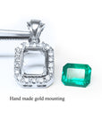 Handmade gold-mounted emerald pendant on a white background.