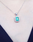 Emerald pendant necklace on a person's neck.