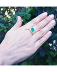 Emerald-cut men's emerald ring, 2.52 carats, bezel set in 18K yellow gold on a hand.