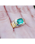 Men's emerald-cut emerald ring, 2.52 carat, bezel set in 18K yellow gold with diamond accents.
