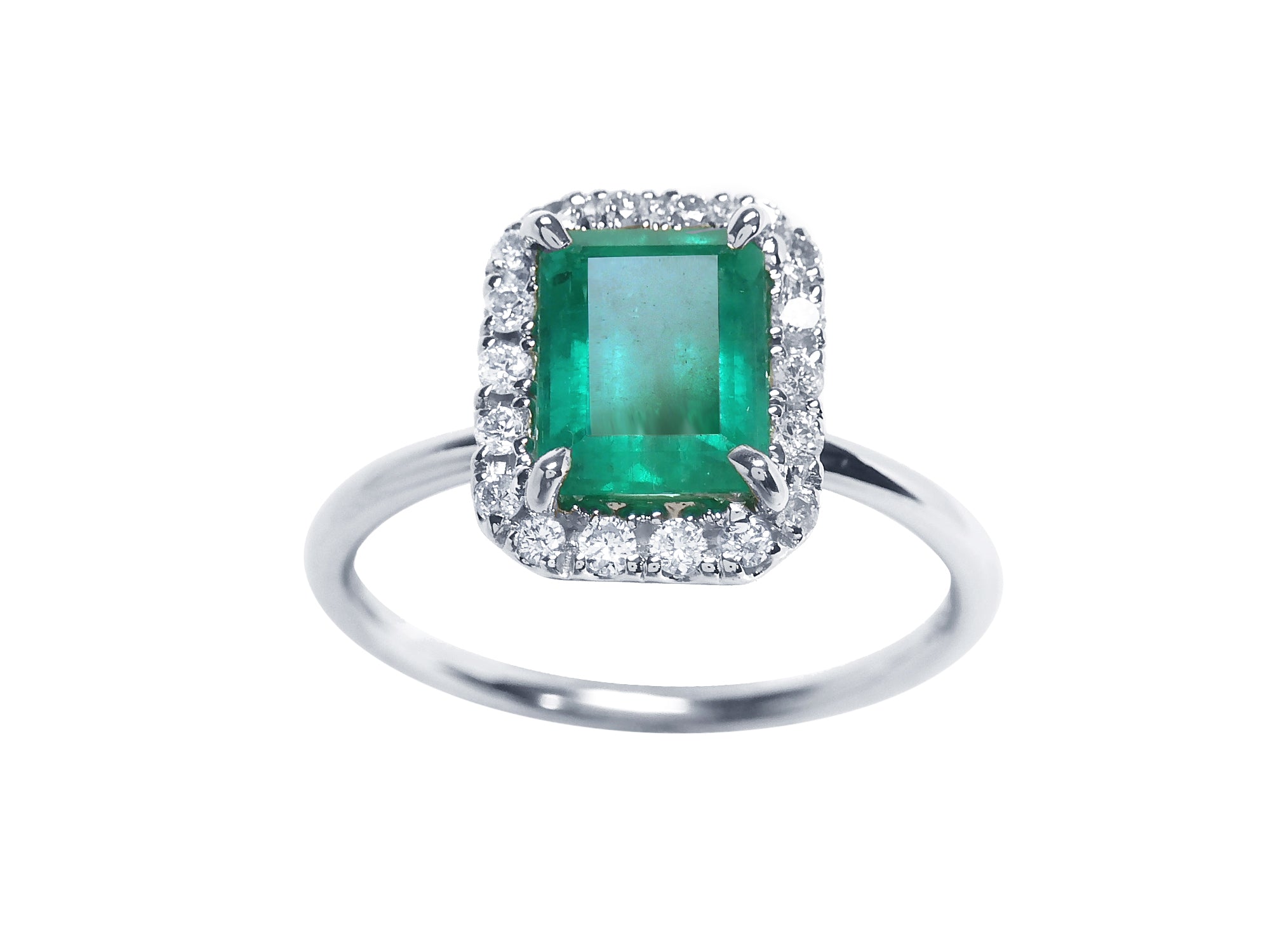 A colombian emerald encircled by a halo diamond emerald ring in white gold.