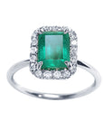 A colombian emerald encircled by a halo diamond emerald ring in white gold.