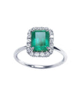 A colombian emerald encircled by a halo diamond emerald ring in white gold.