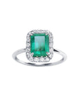 A rectangular emerald-cut encircled by a halo diamond emerald ring in 1k white gold topside view.