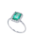 A semi-lateral view of a natural colombian emerald into a halo diamond in 14k white gold ring.