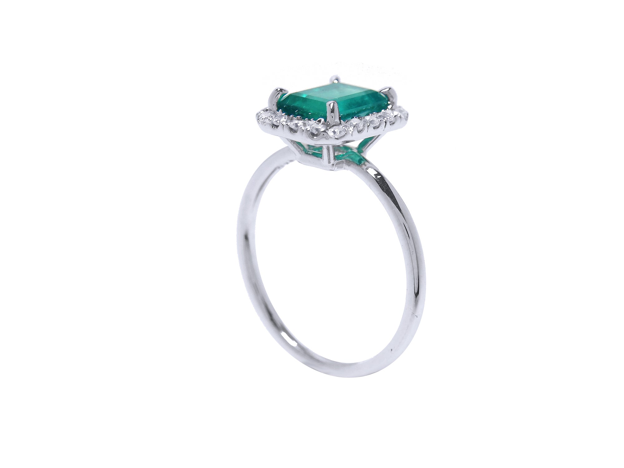 Emerald and diamond ring in white gold side profile view.