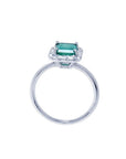 Emerald-cut Muzo emerald halo diamond ring in 14K white gold.
