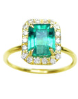 A rectangular emerald encircled into a halo diamond ring topside view.
