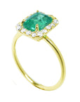 An emerald-cut halo diamond emerald ring in half side position, top setting and band profile displayed.