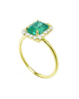 An emerald-cut halo diamond emerald ring in half side position, top setting and band profile displayed.
