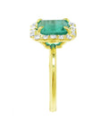 This natural emerald with a halo diamond ring is displaying the gemstone side and band profile.