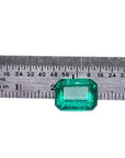 Vibrant bluish-green 4.18 carat emerald-cut loose emerald from Muzo, Colombia, next to a ruler.