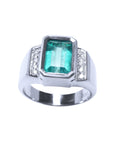 Men's white gold emerald ring bezel set with accent diamonds on a topside view and sideways displayed.