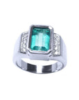 Men's 18K white gold ring with a bezel-set emerald-cut bluish-green emerald and side diamonds.