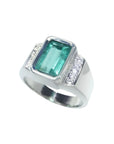 Men's 18K white gold ring with a bezel-set emerald-cut bluish-green emerald and diamond accents.